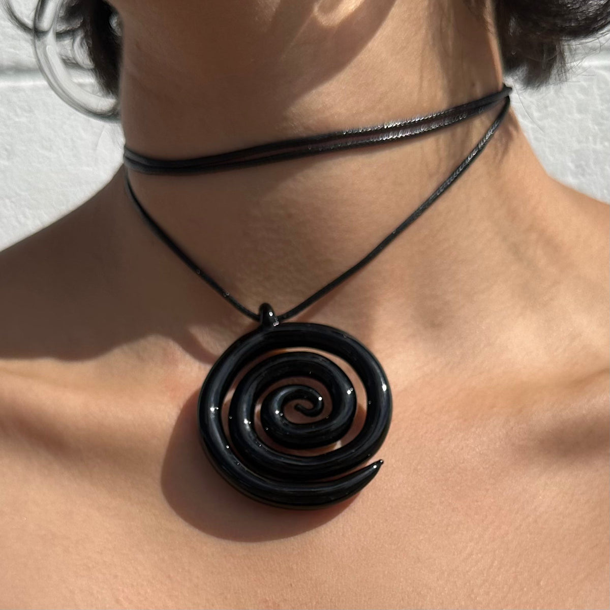 Elegant black spiral ring, modern design, jewelry close-up. Image 2 of 3.
